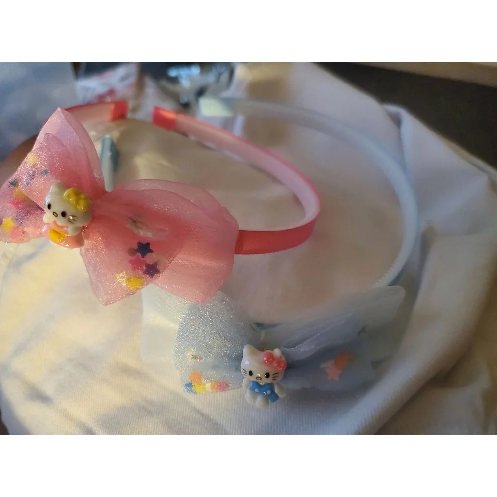 Four Hello Kitty headbands with small figurine